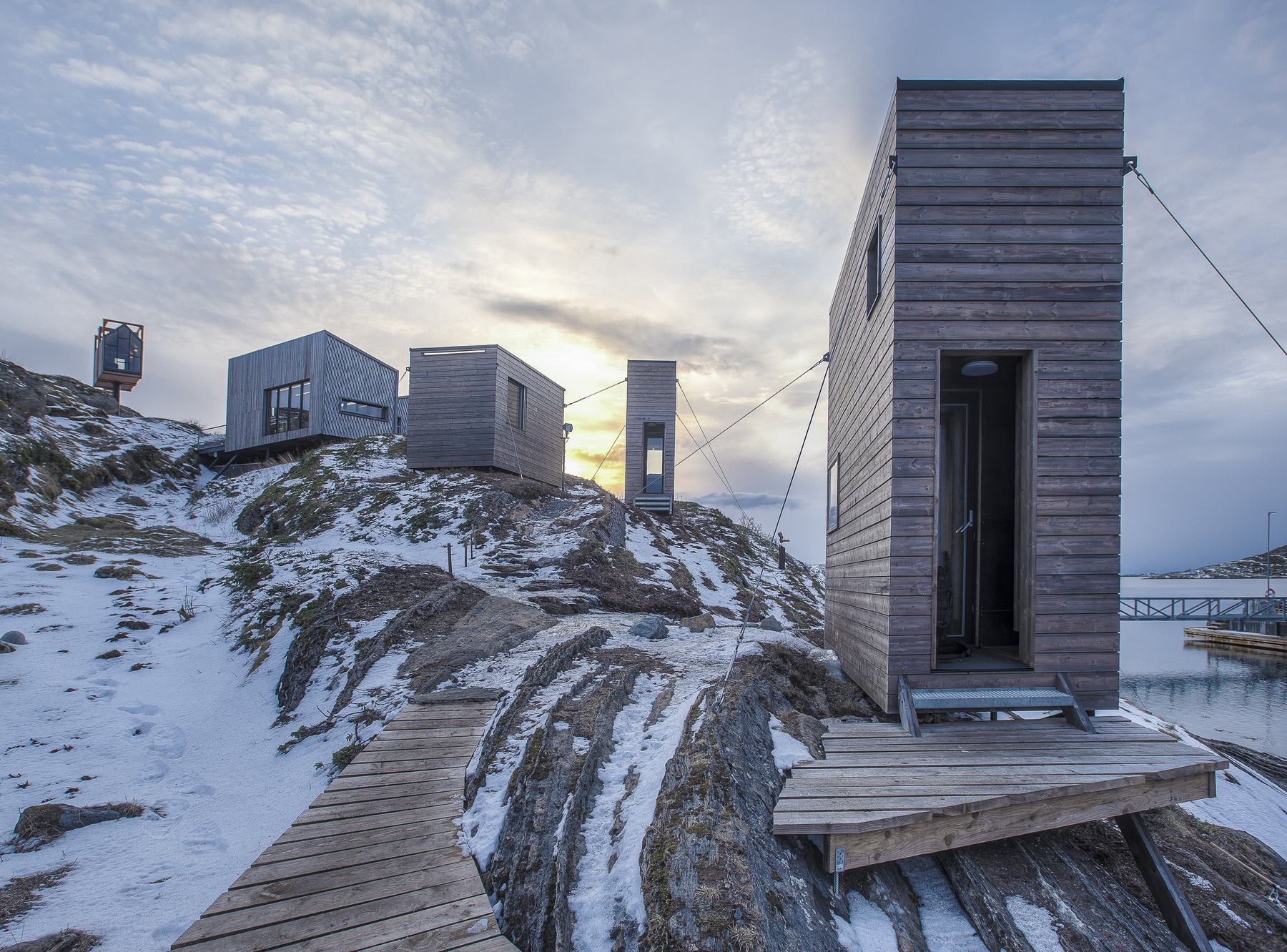 The Tower House and cabins on snowy rock, a boardwalk leading between them