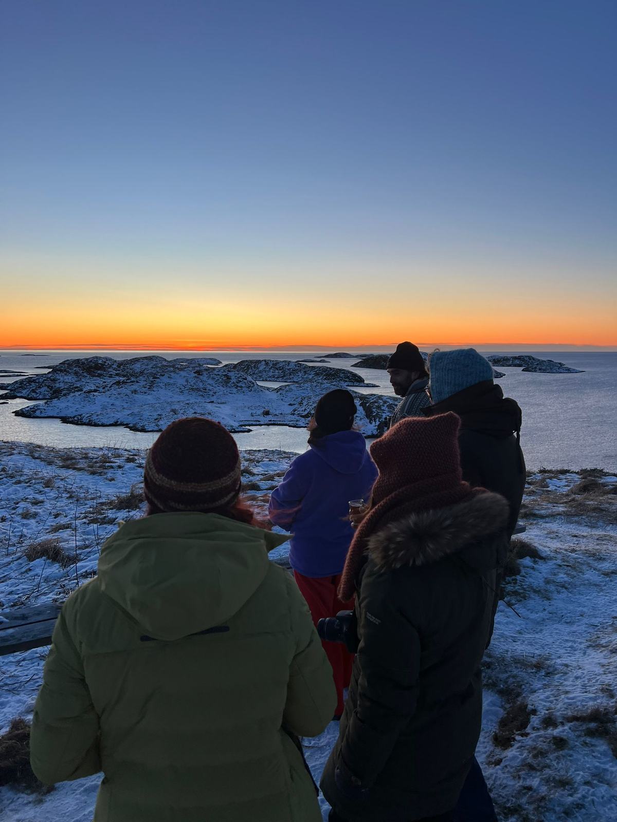 Residents on the hilltop watching the sun set over the islands