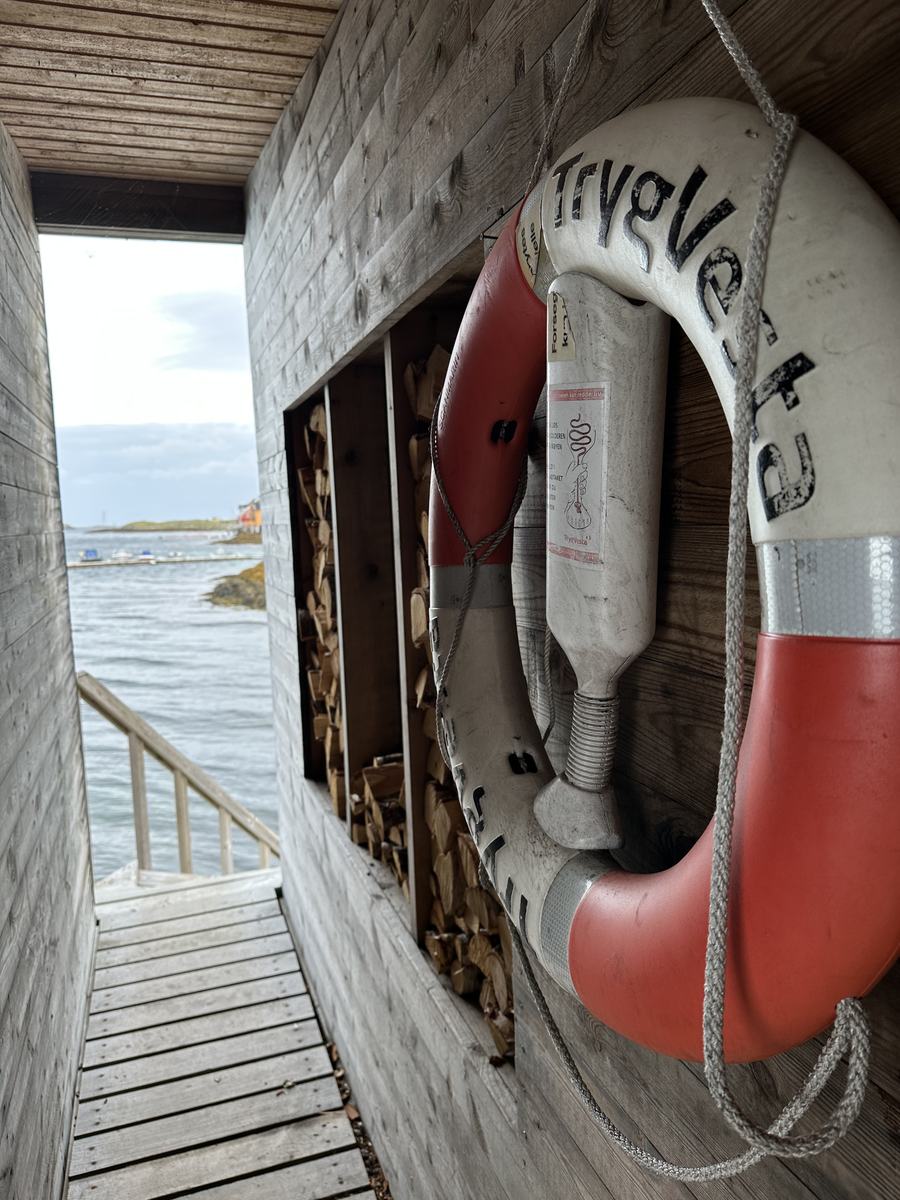 A life ring hanging on a weathered wall above the boardwalk