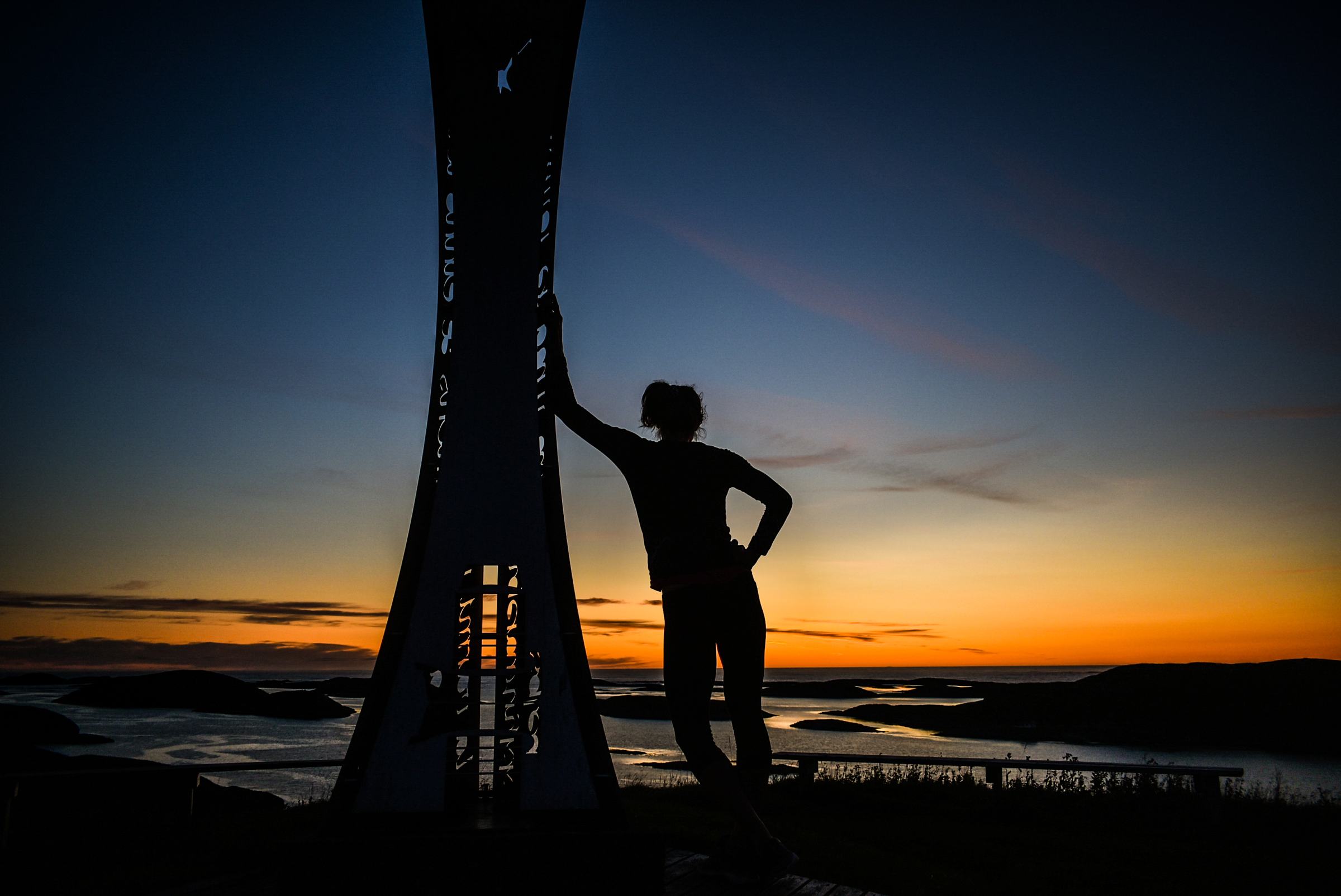 A figure in silhouette on the hilltop at sunset