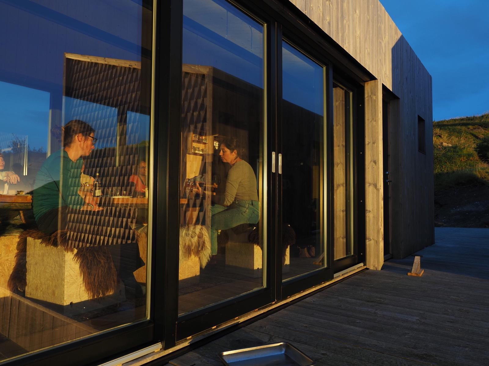 Guests around the table in the Kitchen House in the evening