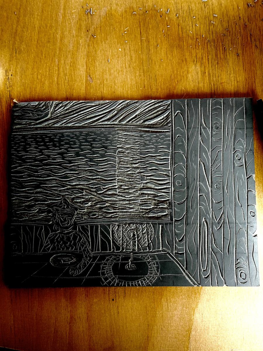 A carved lino block on the wooden table