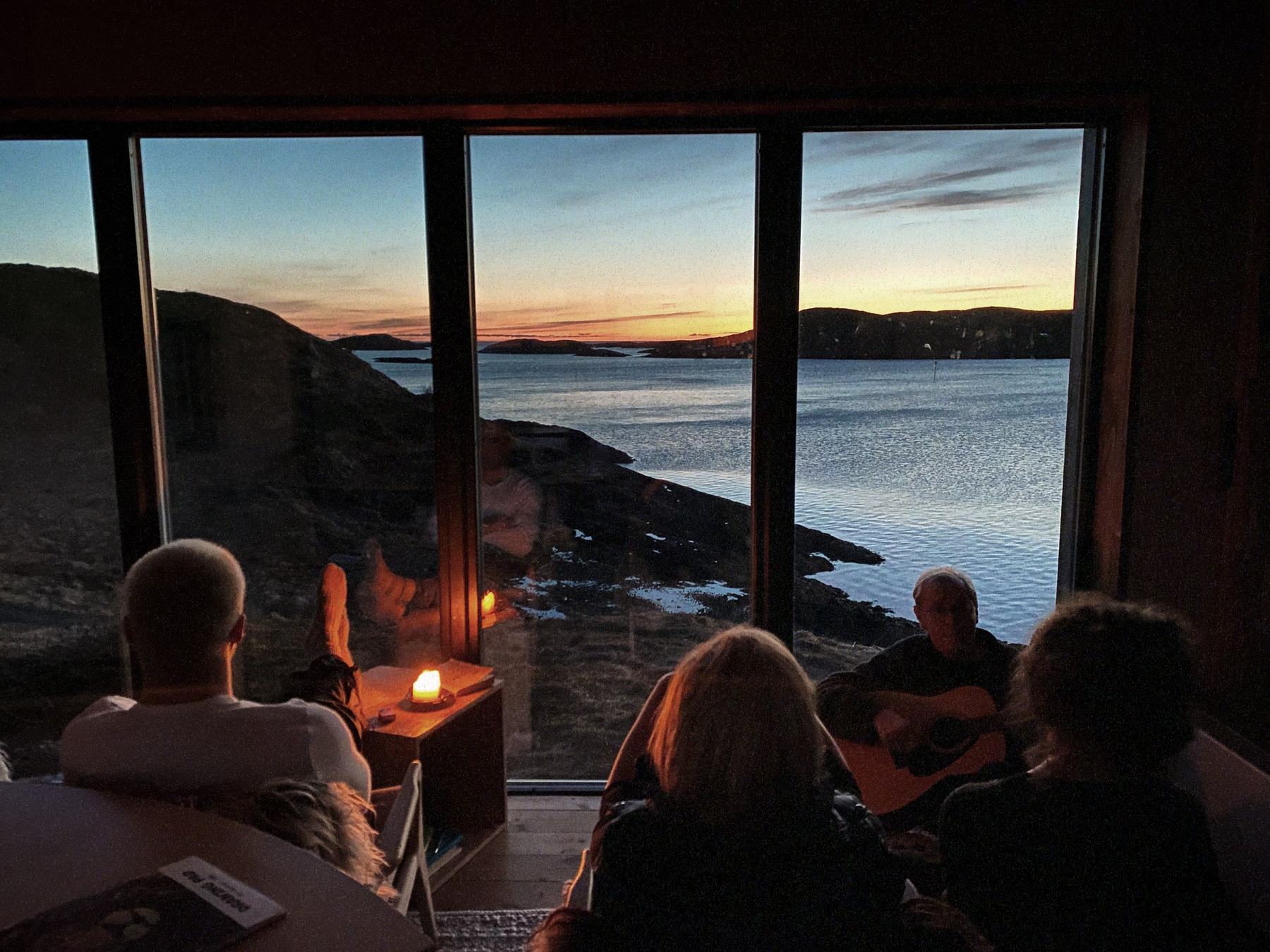 Residents gathered by candlelight at the window, watching the sunset