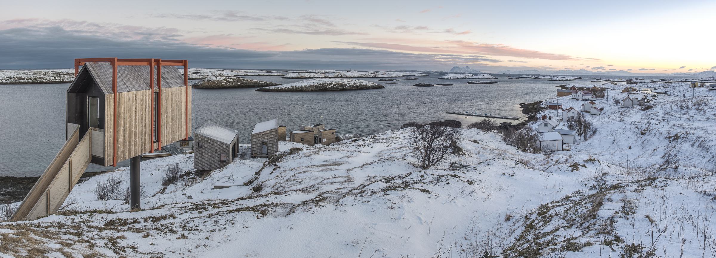 Panorama of the cabins and the snowy island at dusk