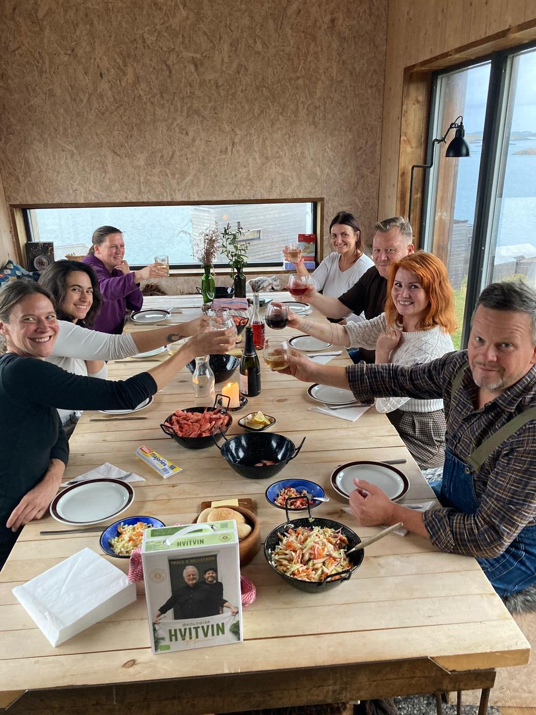 A group around the dinner table in the Kitchen House, raising glasses